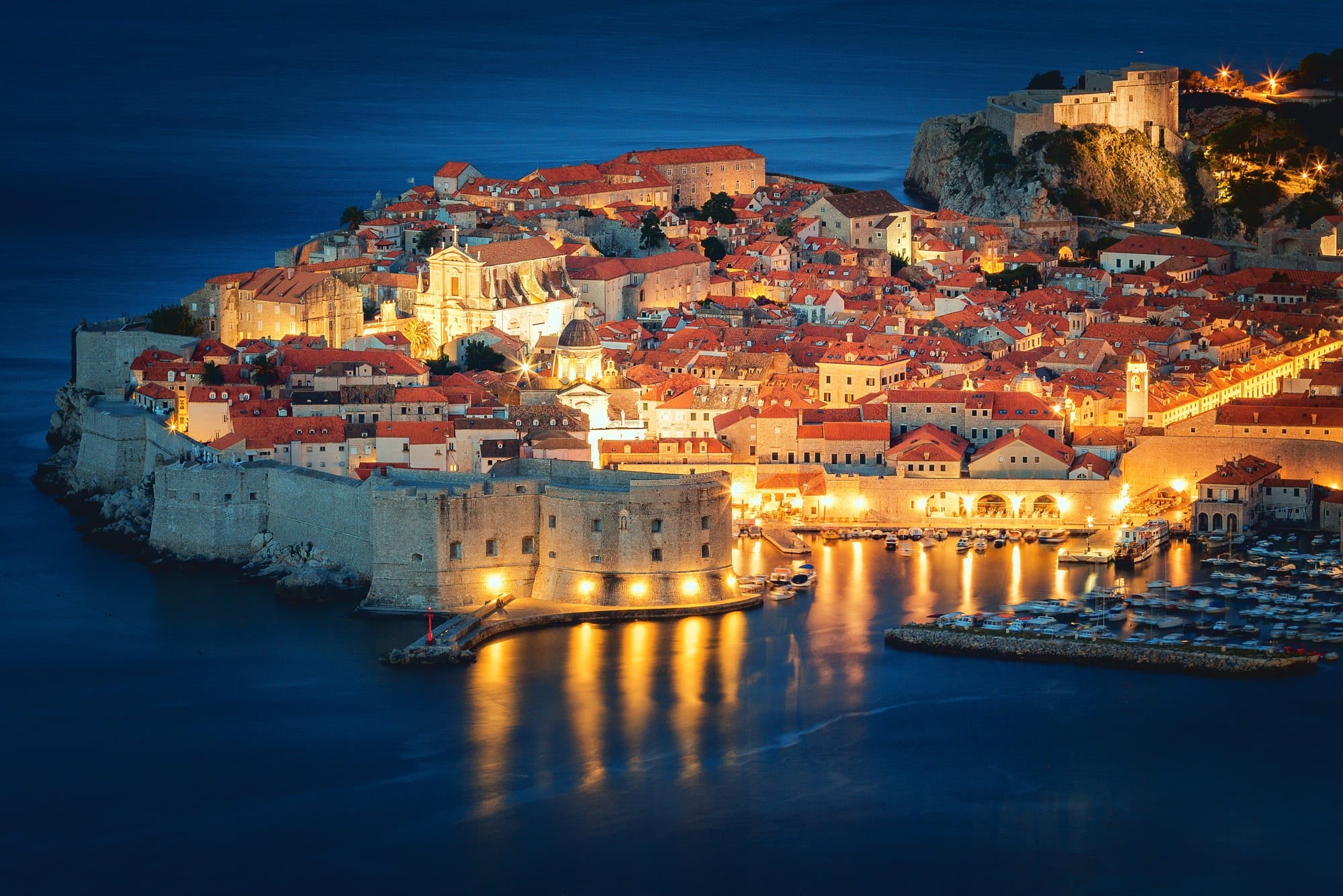 Aerial view of Dubrovnik's terracotta rooftops meeting the Adriatic