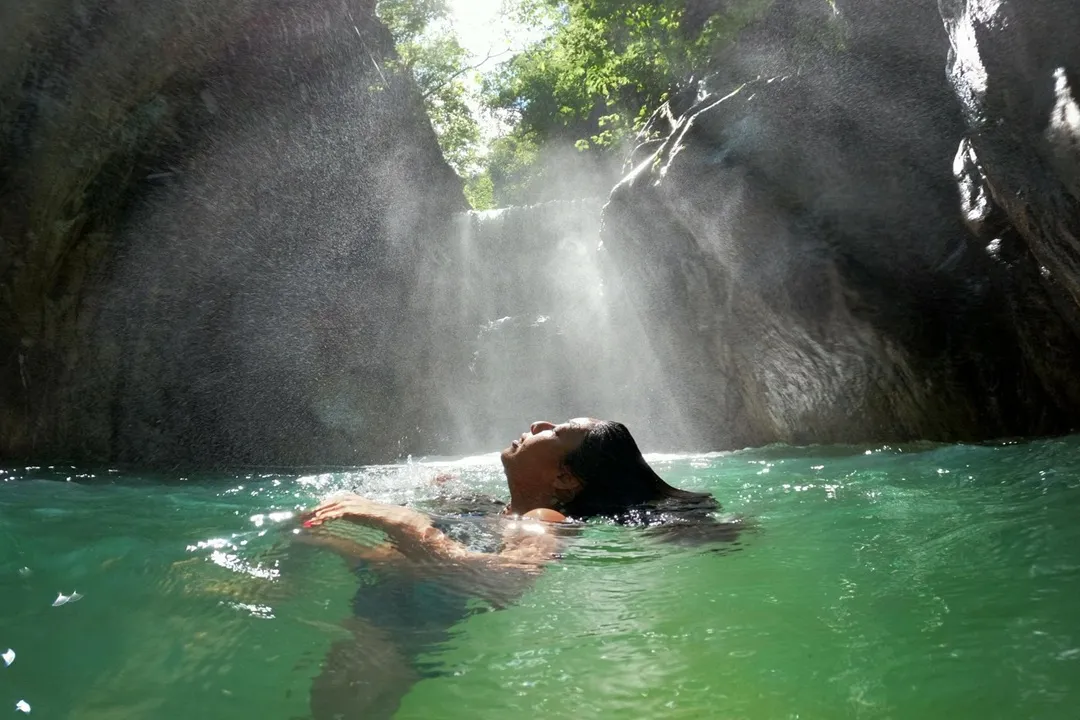 Swimming in a jungle waterfall pool