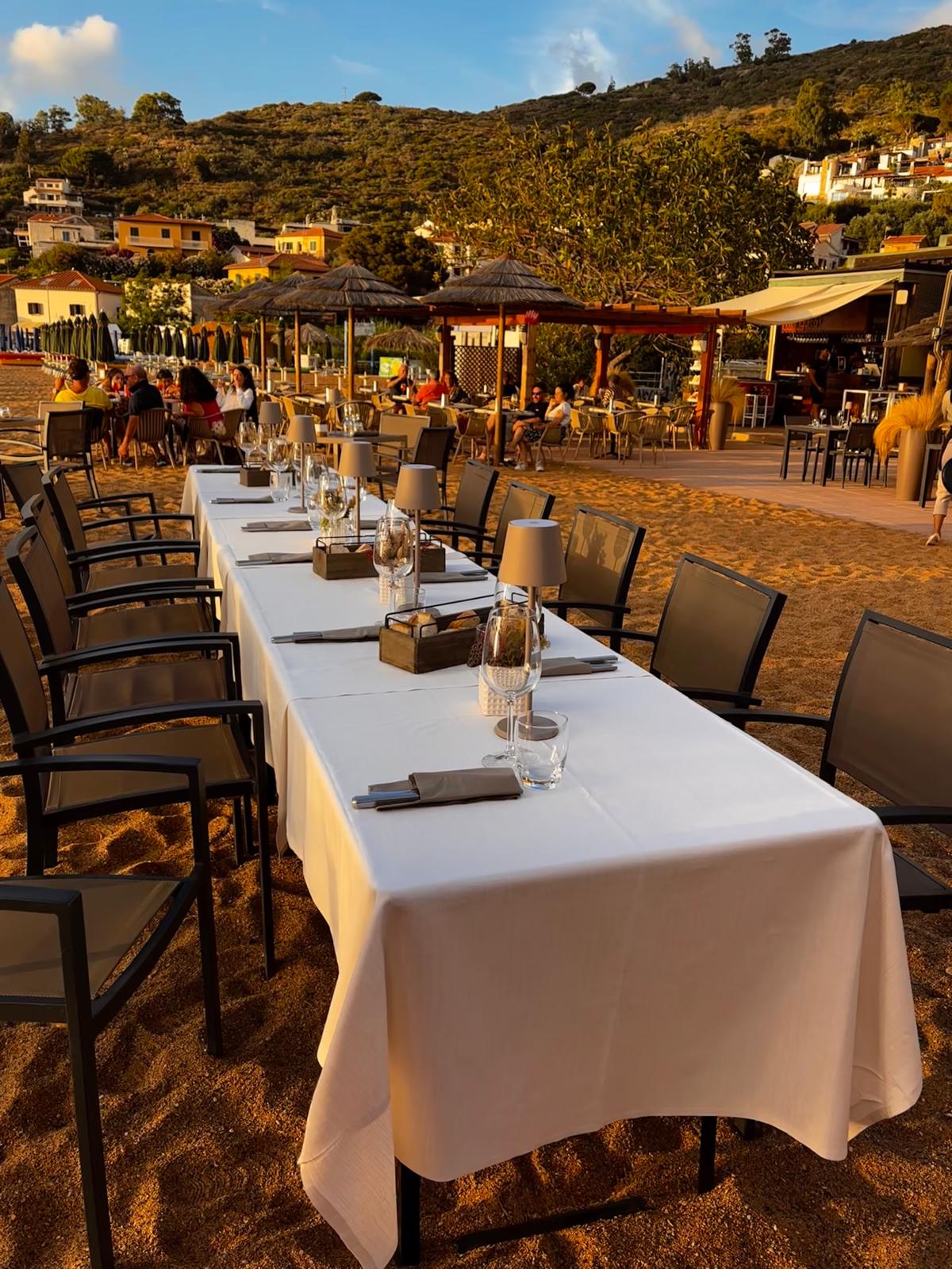 Long table set for dinner on the beach