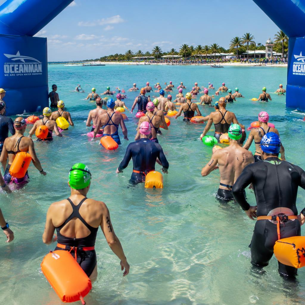 Open water swimmers at a festival swim start in a Caribbean bay